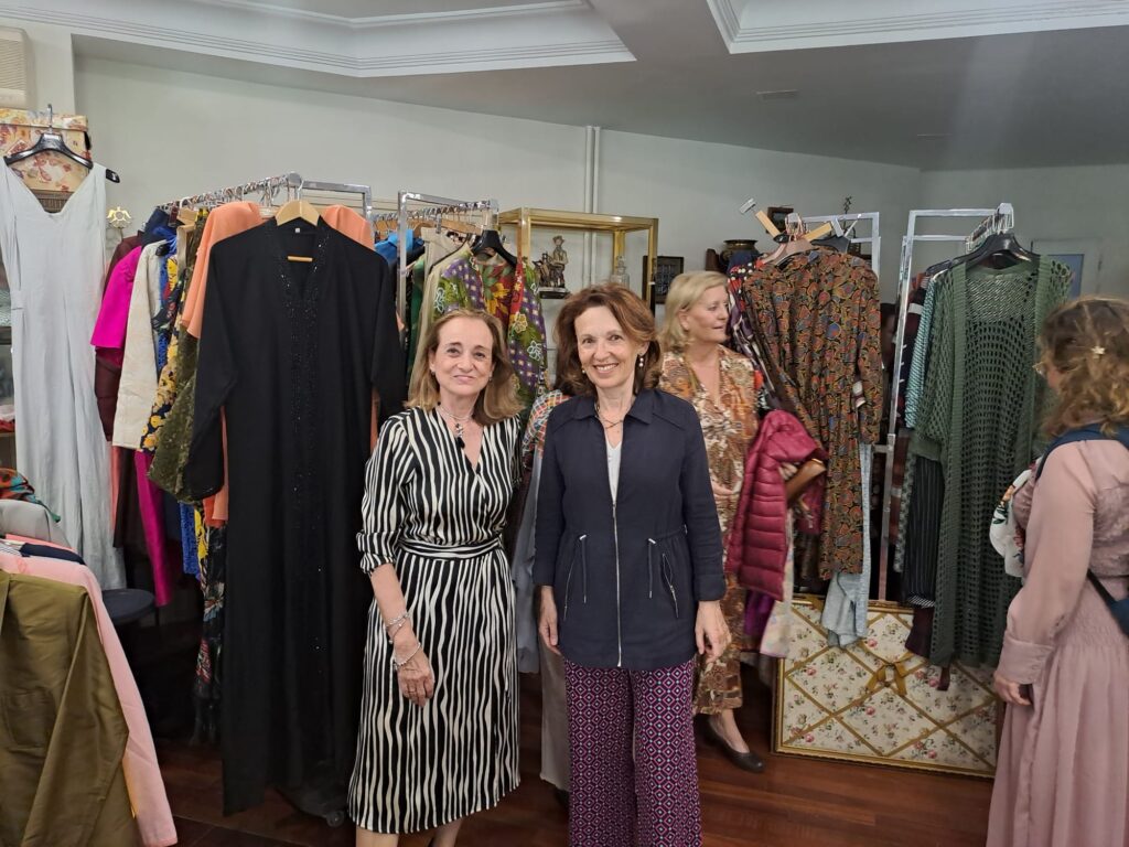 Rosana y Carmen, de izquierda a derecha, sonríen en un local lleno de ropa.